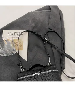 Detail of woven texture black crossbody camera bag with adjustable shoulder strap