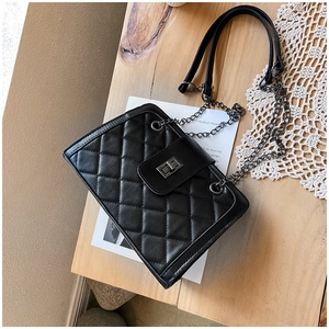 Close-up of black quilted leather texture and metallic chain strap on a crossbody bag