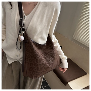 Detail of leopard print hobo bag featuring a matte texture and baseball-themed charm