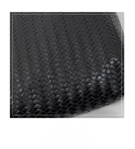 Macro detail of high-quality black leather in a classic hand-woven cross pattern