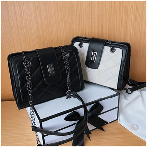 Detailed view of quilted chain bags with metal clasp on a gift box background