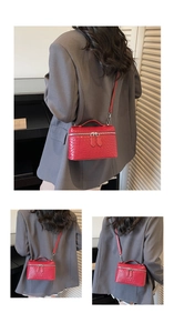 Detail of red woven texture cosmetic box bag with top handle and crossbody chain strap