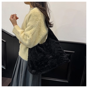Détail de la texture douce du sac à bandoulière en peluche noire porté par le mannequin