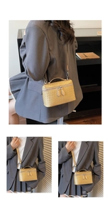 Macro view of woven textured golden-brown box bag with silver zippers and leather strap