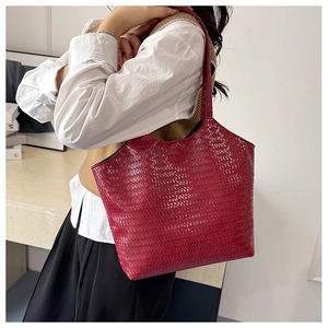Detail view of the glossy red woven texture on a stylish French designer tote bag