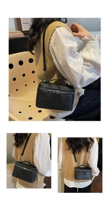 Detail of black woven leather texture and metal zipper on square crossbody vanity bag