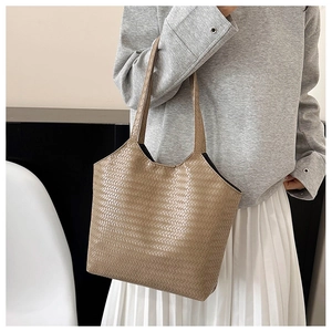 Detailed texture of khaki woven shoulder bag on a model for a minimalist commute look