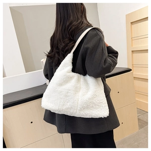 Détail d'un sac bandoulière en peluche blanche avec sangle en cuir sur modèle