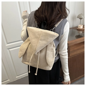 Dettaglio di uno zaino beige con orecchie da coniglio, coulisse e trama morbida