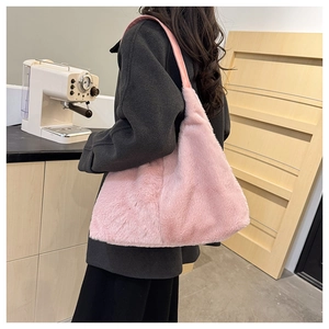 Détail du sac à épaule en fausse fourrure rose montrant sa texture douce et sa capacité