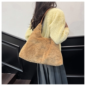Détail d'un grand sac cabas en peluche marron porté sur un pull d'automne jaune