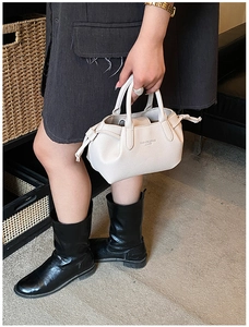 Close-up of beige lychee leather tote bag featuring fashion text and drawstring detail