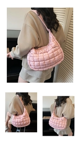 Detailed close-up of pink quilted bubble puffer shoulder bag with soft textured fabric