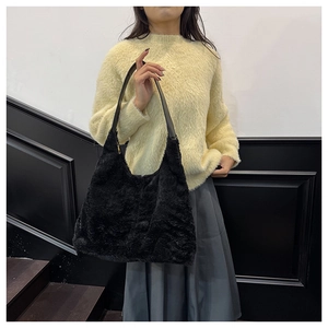 Détail du sac fourre-tout noir en fausse fourrure douce avec bandoulières en cuir souple