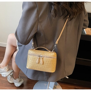 Detail of woven texture shoulder bag with chain strap and top handle in light brown