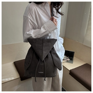 Detailed view of a dark grey suede backpack with cute rabbit ears and drawstring closure