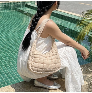 Detailed view of beige quilted nylon shoulder bag with puff texture and wide strap