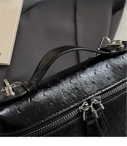 Detail of black ostrich leather texture handbag featuring silver zipper hardware