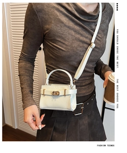 Vue détaillée du mini sac en cuir crème grainé avec boucle dorée et poignée ronde