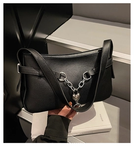 Detail of black pebbled leather underarm bag with silver chain and heart padlock