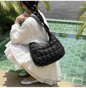 Close-up of a black quilted hobo bag featuring a semi-moon design and nylon fabric