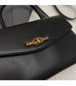Detailed close-up of a vintage black lychee texture handbag with a gold metal turn-lock