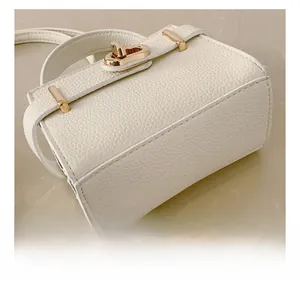 Détail du sac à main blanc en cuir grainé litchi avec fermoir pivotant doré