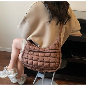 Rear view of brown quilted nylon crossbody bag with puffy square texture and wide strap