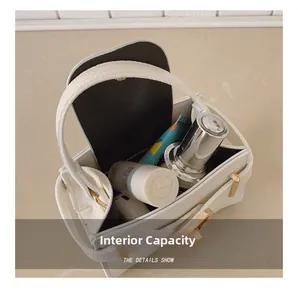 Vue intérieure du sac à main en cuir grainé blanc montrant l'espace de rangement
