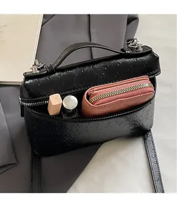 Top view of ostrich pattern handbag interior showing storage for wallet and makeup