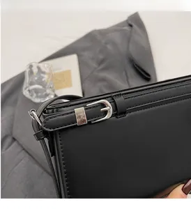 Detailed close-up of premium silver hardware and fine stitching on a black leather handbag