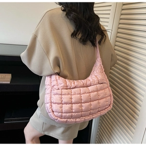 Pink quilted nylon hobo bag shown from a back view on a model for a casual look