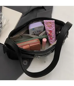 Top view of black pebbled leather bag interior showing spacious capacity with daily essentials