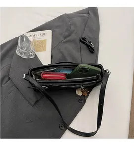 Interior detail of black leather baguette bag showing spacious storage for phone and wallet