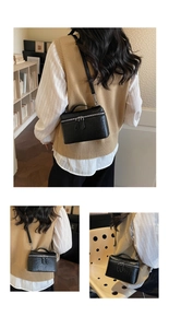 Detail of black box vanity bag with ostrich pattern texture and silver double zippers