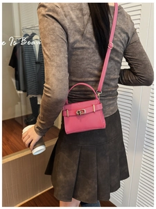 Détail du mini sac en cuir litchi rose fuchsia avec fermoir rotatif doré brillant