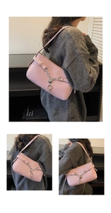 Detail of light pink lychee texture leather bag with silver heart charm and chain