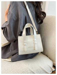 Detail of a white faux leather crossbody bag with Fashion & Bags text on model