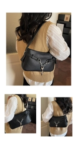 Close-up of black lychee texture leather bag with silver chain and heart pendant