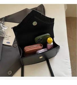 Interior view showing storage capacity of black leather bag with phone and wallet