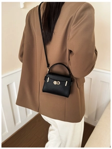 Chic black litchi texture crossbody bag styled with professional women's blazer