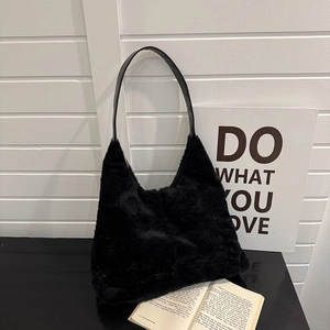 Sac fourre-tout en peluche noire minimaliste avec bandoulière en cuir dans un studio