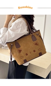 Detail of tan tote bag with cat face embroidery and contrasting brown straps
