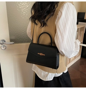 Classic black crossbody bag with vintage gold lock shown in a stylish home setting
