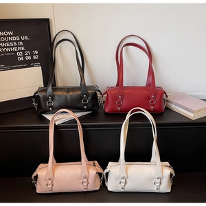 Borse a tracolla cilindriche in pelle nera, rossa, rosa e bianca con anelli metallici decorativi