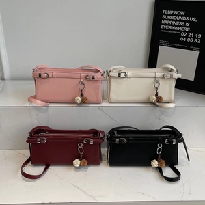 Minimalist square crossbody bags in pink, white, red, and black on marble steps