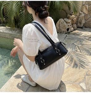 Borsa sottobraccio in pelle nera con anelli argentati e borchie a bordo piscina