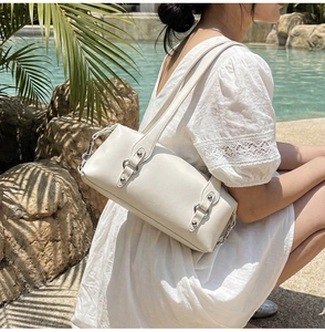 Dettaglio della borsa bianca con anelli in metallo argento e borchie decorative