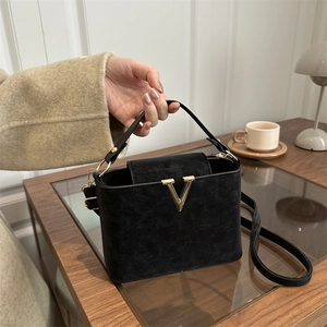 Chic black bucket handbag with gold V-hardware and versatile adjustable shoulder strap