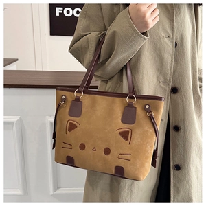 Détail de la broderie chat et de la texture en daim sur le grand sac cabas marron